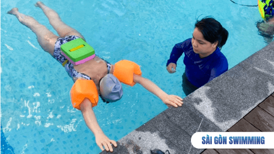 Giáo viên đang hướng dẫn học viên nữ tập bơi cơ bản 